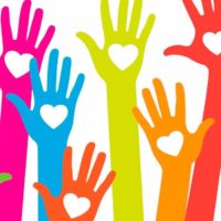 colourful hands in the air with hearts for kindness