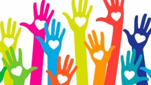 colourful hands in the air with hearts for kindness