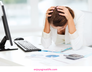 woman sitting at computer with head in hands stressed