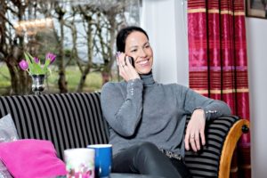 Woman Sitting at home on mobile phone